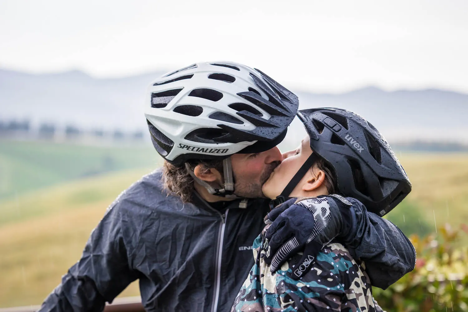 Two riders kissing, helmets on