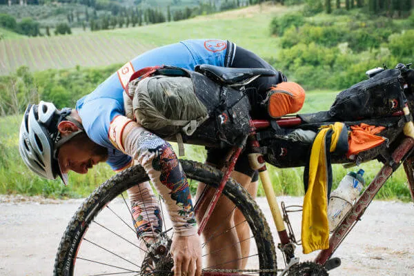 A rider slumped over the handlebar, exhausted