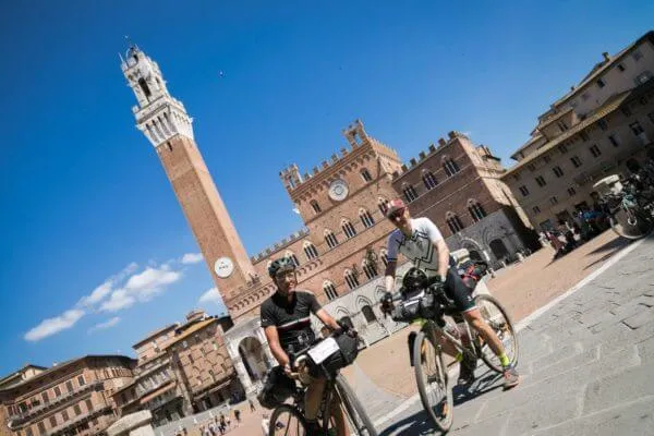 Riders below the Torre del Mangia in Siena