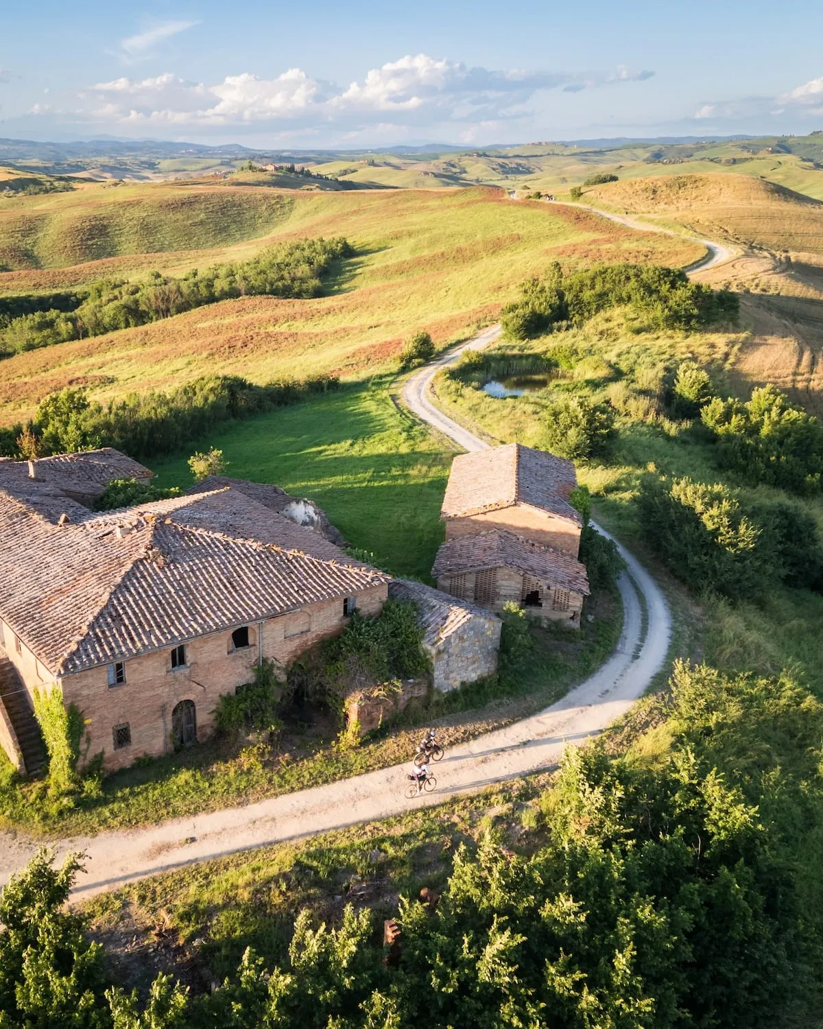Un casale toscano visto dall'alto, con la strada bianca che gli passa accanto