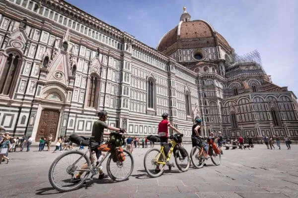 Riders with loaded bikes in front of Florence Cathedral