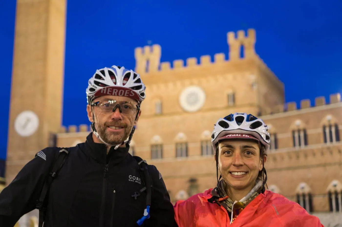 Two riders taking a selfie in front of Siena's Palazzo Pubblico
