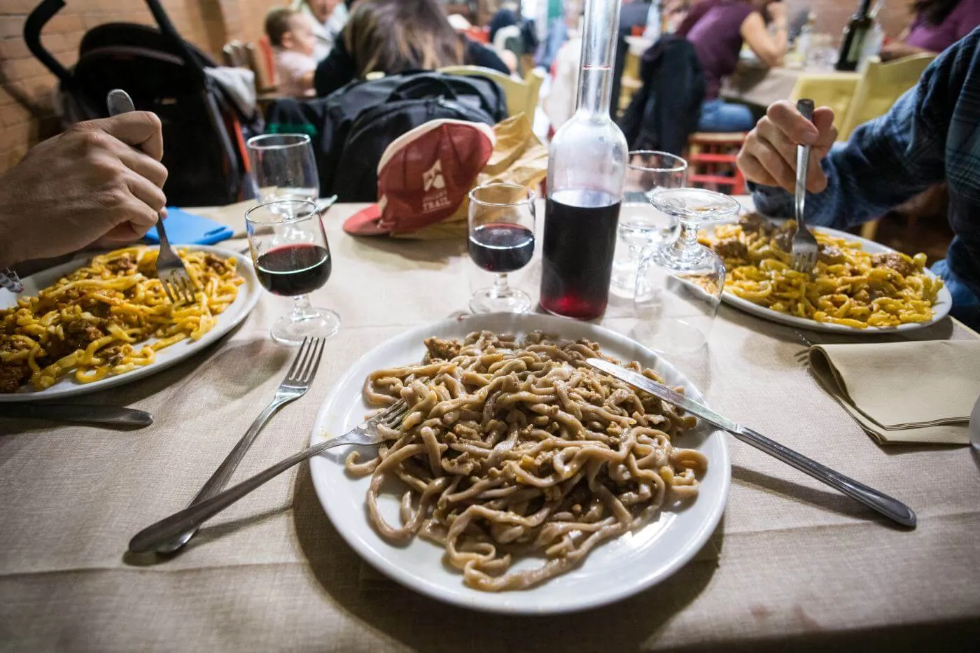 A plate of pasta and a glass of wine on the table