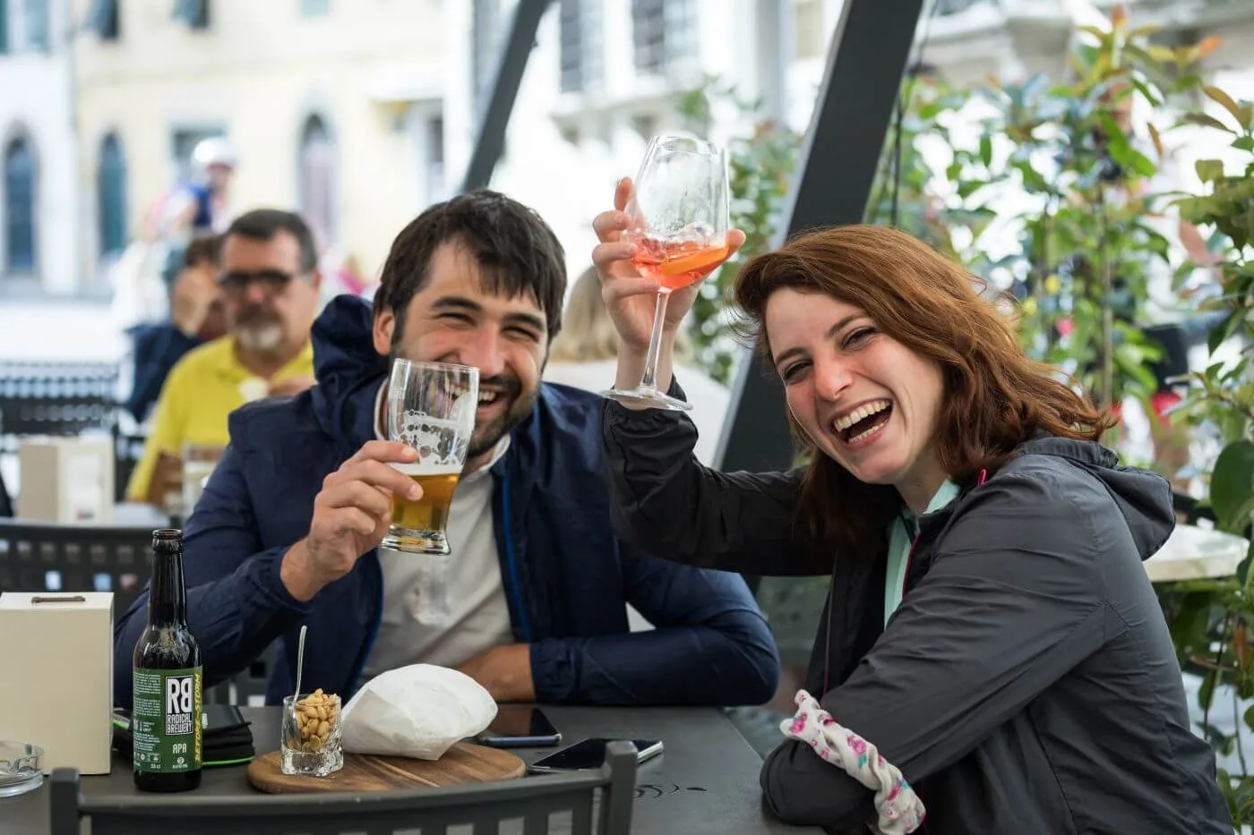 Two people toasting at a bar table